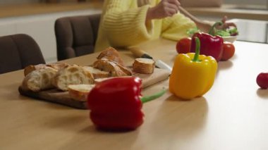 Mutfaktaki mutlu beyaz aile 10 'lu yaşlarda, küçük beyaz kız çocuğu vejetaryen, sağlıklı yemek pişiriyor, salata yapıyor sebzeleri karıştırıyor, baba destek oluyor, sarılıyor, kızı kucaklıyor.