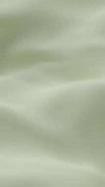 Yumuşak bej ipek kumaş yumuşak dalgalar oluşturarak zarif minimum arkaplan dokusu yaratarak tazeliği, sakinliği ve tasarım videosu veya dekor temaları için lüks estetiği sembolize eder.