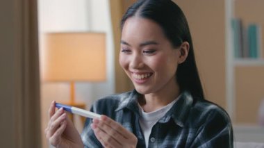 Mutlu, hamile, Asyalı bir kadın, hamile, hamile, hamile, hamile, hamile, hamile, anne, baba, bebek, bebek, aile çocuğu doğururken gülümsüyor.