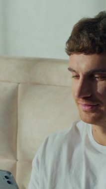 Beyaz adamın evde oturup cep telefonuyla Avrupalı bir erkeğe mesaj atması sohbet sohbetinin keyfini çıkarması mesajlar yazması akıllı telefonlara bakması dinlendirici yatak odasında dinlendirici rahatlama.