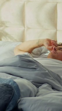 Dinlenmiş Kafkasyalı bir adam yatağında uyanıyor gülümseyen bir erkek çocuk sabah rahat rahat yatak odası uykusunda uyukluyor kiracı ev sahibinin ev sahibi olma zevkini evde uyukluyor.