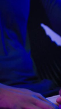 Koyu fütüristik odada dizüstü bilgisayar yazan Afrikalı Amerikalı bir adam. Erkek hacker bilgisayar fütürizmi modern teknoloji veritabanı siber uzayı internet kullanarak kulaklıkla müzik dinliyor.