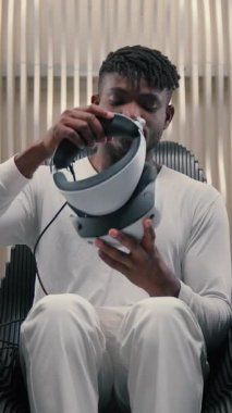 Afrikalı Amerikalı bir adam VR miğferini fütüristik uzay modern yenilikçi cihaz teknolojisine yerleştiriyor. Sanal gerçeklik kulaklık simülasyonu yapan adam kullanıyor. Modern gelecekçilik yazılımını iş için kullanıyor.