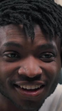 Close up happy African American man put on headphones gadget listening music active energetic dancing singing in futuristic room male guy smiling joy fun freedom sing dance enjoying song cyber app