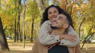 Sonbahar parkında sırılsıklam aşık İspanyol bir çift kucaklaşıyorlar sevgi dolu bir ilişki gülümseyen Arap bir kadın erkek erkeğe omuzlarından sarılıyor açık havada aile, sonbahar sezonunda dışarıda dinleniyor.