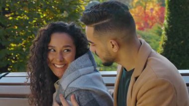 Sonbahar parkında Latin kökenli Arap bir çift. Kareli battaniyeli hoş bir adam. Soğuk hava koruma sevgilisinin kız arkadaşıyla kucaklaşması.