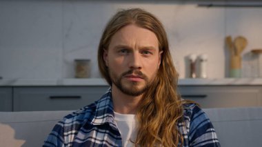 Serious concentrated Caucasian man watching TV at home apartment male focused frowning surprised amazing news reaction smiling unexpected joy guy enjoying movie film indoors facial expression emotion