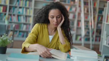 Uykucu Latin kadın öğrenci kitap okuyor zor sınavlar hazırlıyor kütüphanede sıkılıyor üniversitede okuyan kız öğrenci üzgün sayfaları öğreniyor lise eğitimi seanslarından bitap düşüyor