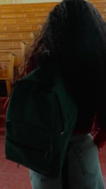 Arkadan bakan İspanyol öğrenci kız üniversite konferansına giriyor. Sırt çantasıyla yürüyen heyecanlı bayan Latin bayan. Büyük boş bir üniversite akademisine giriyor.