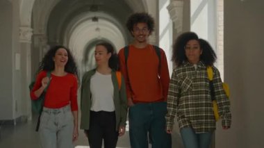 Mutlu çok ırklı grup. Üniversite koridorunda yürüyen dört öğrenci gülümseyen çeşitlilikten bahsediyorlar. Afro-Amerikan Latin sınıf arkadaşları.