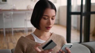 Evdeki İspanyol kadın internet üzerinden akıllı telefon kredi kartı kullanıyor. Beyaz kız, kadın, yemek siparişi, cep telefonu, uygulama, internet ödeme mağazası, rezervasyon.