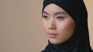 Siyah tesettürlü Müslüman bir kadın ciddi yüzünü yana çeviriyor düşünceli Müslüman bir bayan yalnız başına üzgün din ayrımcılığı inanç kimliği zihinsel acı sağlık kozmetolojisi