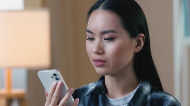 Kafası karışmış Asyalı bir kadının cep telefonuyla konuşması endişeli bir kadının kötü bağlantıları hayal kırıklığına uğramış Japon kız akıllı telefonunun konuşması hücresel sorun, bozuk cihaz iletişimi.