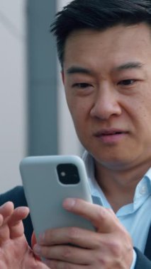 Asyalı mutlu iş adamı telefon kazanmasıyla şaşırdı Koreli iş adamının sevinç cep telefonu başarısı Japon yöneticinin şehirde cep telefonuyla iyi haberler okuması Çinli erkek kumarhane parası kazandı.