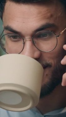 Mutlu Müslüman gülümseyen Hintli işadamı cep telefonuyla konuşuyor, kahve içiyor, kahve içiyor, iş adamı gülüyor, Arap işvereni içkisini içiyor, akıllı telefon iletişiminden memnun.