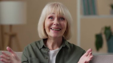 Duygusal olarak heyecanlı, beyaz, yaşlı bir kadın kameraya bakıyor. Mutlu, mutlu bir ağız açıyor. Harika bir teklif.