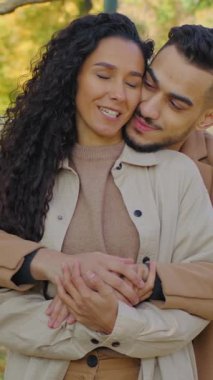 Sonbahar parkında kucaklaşan İspanyol çift erkek, güz şehrinin arka tarafındaki sevgili kıza sarılıyor. Sohbetin tadını çıkarıyor. Kocasıyla hafifçe sarılıp sarılıyorlar.