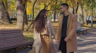 Mutlu Arap çift güz parkında yürüyüp eğleniyor İspanyol aile birlikte yürüyor gülümsüyor konuşan evli beyaz kadın etrafında dönüyor sonbahar sezonunda bir adamla el ele tutuşuyorlar