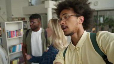 Web kamerası görüntüsü dört farklı öğrencinin mutlu bir şekilde gülümseyip selfie çektikleri sosyal medya vlog 'u çok ırklı insanlar üniversitede cep telefonu kamerasıyla fotoğraf çeken kaygısız arkadaşlar gülümsüyor.