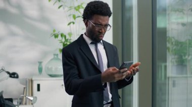 Afro-Amerikalı işadamı hayal kırıklığına uğramış cep telefonunu rahatsız eden, sohbet eden akıllı telefon iş adamı cep telefonu tutan, elinde negatif haber arızası olan bir adam.