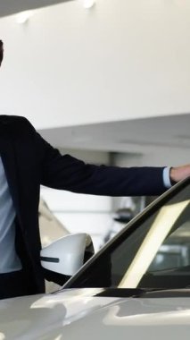 Kafkasyalı iş adamının otomobil galerisinden yeni bir araba seçmesi heyecan verici. Mutlu alıcı rüya gibi bir araca dokunuyor. Müşteri tatmin oluyor.