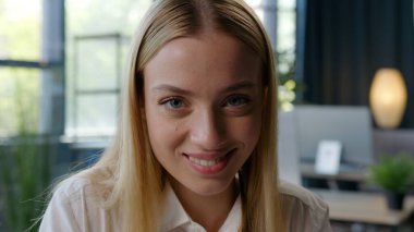 Gülümseyen mutlu beyaz iş kadını ofiste kameraya bakıyor neşeli kız iş kadını temsilci şirket gülümsemesi kadın şirket çalışanı uzman iyi iş çıkartıyor.