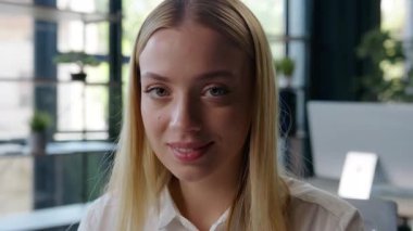 Gülümseyen mutlu beyaz iş kadını ofiste kameraya bakıyor neşeli kız iş kadını temsilci şirket gülümsemesi kadın şirket çalışanı uzman iyi iş çıkartıyor.