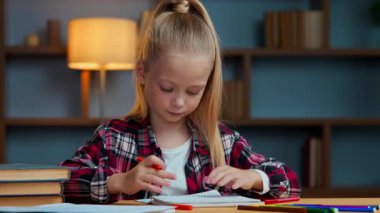 Yaratıcı beyaz kız çocuğu. Renkli kalemlerle resim çizen kız çocuğu. Akşam evde oturan öğrenci çocuk odasında oturmuş resim çiziyor.