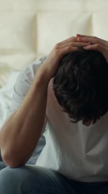 Endişeli Kafkasyalı adam evde oturmuş yatakta başı stresli erkek yatak odasında yorgun, yorgun, baş ağrısı, ağrı, hayal kırıklığı, stres, iç mekan yorgunluğu.