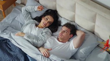 Kafkasyalı mutlu erkek kadın, yatak odasında uzanıp, rahat bir otel odasında sevgili sohbeti yapıyor, kadın koca, sevgili, sevgili ilişkisini tartışıyor.