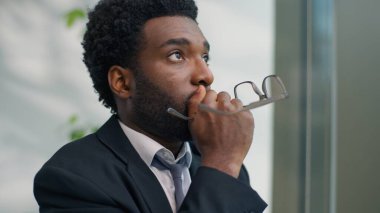 Gergin endişeleri kapat. Depresyondaki Afrikalı Amerikalı iş adamının sorunlu düşünme sorunu. Ofisin penceresine bakmak.