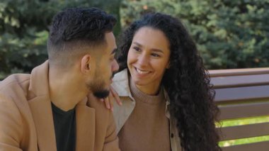 Mutlu İspanyol çift konuşuyor, kahve içiyorlar. Güz parkında gülümsüyorlar. Erkek erkeğe sohbet ediyorlar.