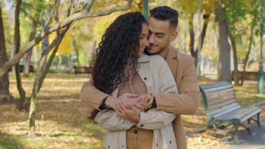 Birbirine aşık İspanyol bir çift, güler yüzlü bir adamla kucaklaşıyor. Sonbahar parkında sevgili sevgilisini kucaklıyor. Sonbahar parkında sarılıyor.