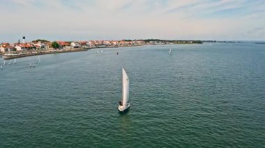 Hava aracı görüntüsü Torreira Portekiz su yatı mavi sularda yelkenli yelkenli yelkenli yelkenli. Atlantik okyanus teknesi turu. Güzellik gezisi tatil seyahati. Balıkçı köyü Portekiz yolculuğu.