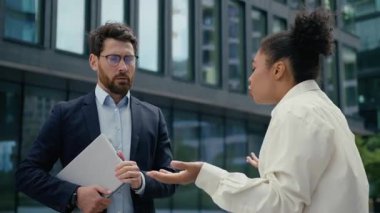 Saldırgan Afrikalı iş kadını patron kızgın, Kafkasyalı iş adamı iki çok ırklı iş adamını kovuyor. Kadın, çatışma liderlerini azarlıyor.