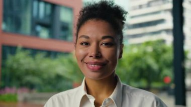 Neşeli, mutlu, Afro-Amerikan iş kadını, kameraya bakıyor, gülümsüyor, şehir merkezindeki iş kadını, kadın, gülümsüyor, kurumsal ajan, müdür, uzman bayan.