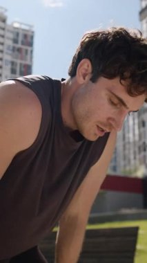 Yorgun, terli beyaz erkek koşucu spordan sonra dinleniyor Avrupalı erkek sporcu soluyor dinlendikten sonra spor yapıyor şehirdeki el nefesiyle alnına ter döküyor.