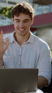 Kafkasyalı iş adamı, iş adamı bankta oturan iş adamı uzmanını kullanarak internet kamerasıyla görüntülü konuşma yapıyor. Şehir merkezinde çalışan bilgisayarla konferans yapıyor.