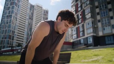 Yorgun, terli beyaz erkek koşucu spordan sonra dinleniyor Avrupalı erkek sporcu soluyor dinlendikten sonra spor yapıyor şehirdeki el nefesiyle alnına ter döküyor.