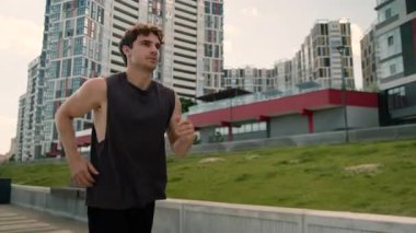Şehre koşan beyaz adam yarışmaya hazırlanıyor. Maraton koşan erkek güçlü atletik, enerjik, sağlıklı sporcu. Hızlı koşu koşucusuna katılıyor.