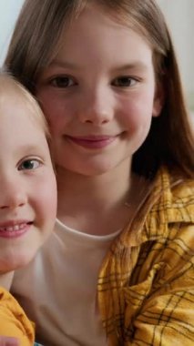 İki mutlu aile kardeş Kafkasyalı kız kardeş küçük çocuklar gülümsüyor kameraya bakıyorlar gülümsüyorlar gülümsüyorlar kucaklaşıyorlar sarılıyorlar kucaklaşıyorlar kucaklaşıyorlar arkadaşlık velayetini kucaklıyorlar