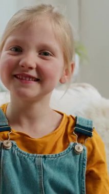 Portre dostu mutlu Kafkas 5 'li küçük kız çocuğu gülümsüyor selam selam veriyor kamera kızına gülümsüyor kamera kamerası görüntüsü konferansında el sallıyor bebek koltukta rahatlıyor