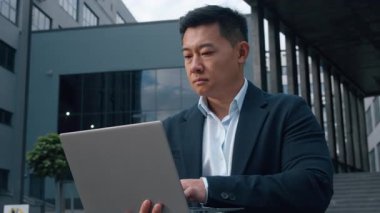 Asyalı işadamı, Koreli iş adamı dizüstü bilgisayar kullanıyor. İnternet üzerinden internet üzerinden müşteri danışmanlığı yapıyor. Siber ortamda çalışan Çinli erkek girişimci.