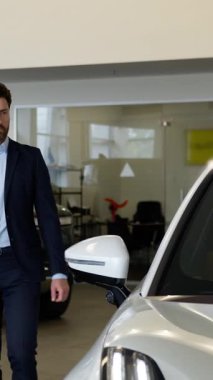 Kafkasyalı iş adamı araba galerisine dokunuyor. Erkek müşteri alıcısı satın alma kararı üzerinde kafa yoruyor. Otomobil kiralama servisi elemanı kuaförde alışveriş yapıyor.