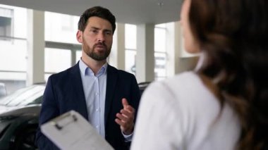 Kafkasyalı kadın müşteriye danışıyor... müşteriyle konuşuyor... yeni araba alıcısı... galeride kadın satıcı... yönetici... tüccar... erkek... otomobil satın alıyor...... araç nakliye aracı...... test sürüşü bayiliği satın alıyor.