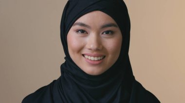 tesettürlü gülümseyen Asyalı Müslüman iş kadını kameraya bakıyor mutlu yönetici kadın profesyonel iş yeri modern İslami kız kendine güvenen gülümseme dişçi başarı kariyerine gülüyor