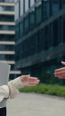 Kafkasyalı iş adamı Afrikalı iş kadınının elinde dizüstü bilgisayarla iş arkadaşlarıyla açık hava ortaklığı hakkında konuştuğu çok ırklı iş adamları tokalaşma toplantısı.