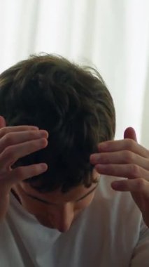 Çaresiz beyaz bir adam yatak odasında başını yatak odasına yaslayarak oturuyor. Avrupa 'lı erkek çocuk umutsuzca zorluklar yaşıyor. Kederi var.