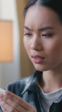 Evde pozitif hamilelik testi tutan hamile bir Koreli kadın endişeli bir kadını şaşırttı plansız hamilelik tepkisi istenmeyen çocuk doğurganlığı.