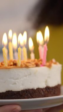 Mutlu çok ırklı aile çifti kanepesinde doğum günü kutluyor gülümsüyor mum üflüyor beyaz adam ve Afrikalı Amerikalı kadın birlikte mutlu bir sürpriz parti eşi istiyorlar.